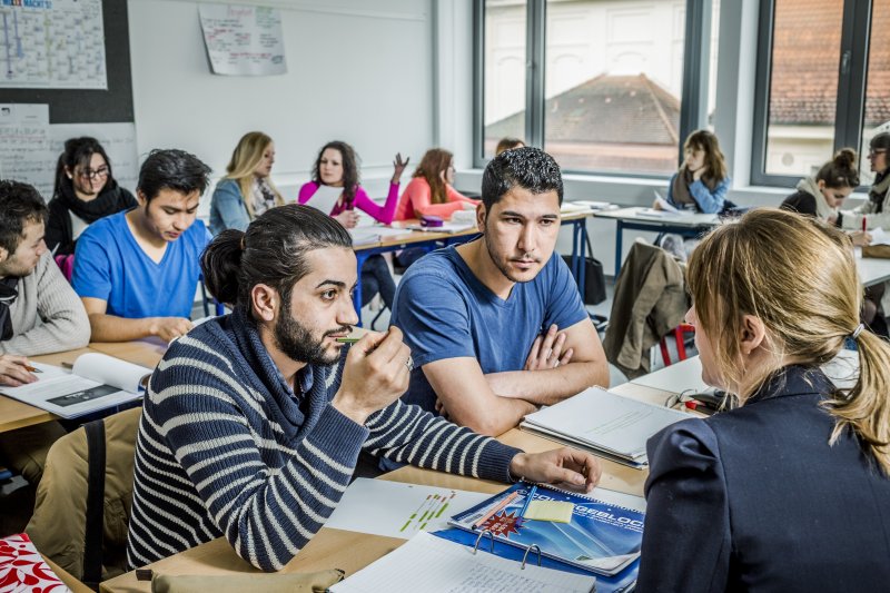 zwei Oberschüler im Unterricht mit einer Lehrerin